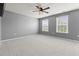 Spacious bedroom with two windows, ceiling fan, and neutral carpet, ready for personalization at 4115 Alvina Way, Myrtle Beach, SC 29579