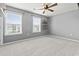Bright bedroom with plush carpet, modern ceiling fan, and two windows overlooking the scenic outdoors at 4115 Alvina Way, Myrtle Beach, SC 29579