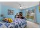 Bright bedroom with blue accent walls, ceiling fan, built in desk with backyard views, and carpet at 4314 Turtle Ln., Little River, SC 29566