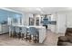 Modern kitchen features an island with seating, white cabinets, and stainless steel appliances, open to the living area at 4314 Turtle Ln., Little River, SC 29566