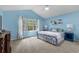 Bright main bedroom with vaulted ceiling, blue walls, a large window, and carpet flooring at 4314 Turtle Ln., Little River, SC 29566