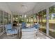 Inviting sunroom with ceiling fan and screened windows offering views of lush backyard landscaping at 4314 Turtle Ln., Little River, SC 29566