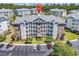 Aerial view of building featuring balconies, parking, and lush trees in a scenic location at 4820 Magnolia Lake Dr. # 305, Myrtle Beach, SC 29577