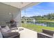 Covered back porch with grill, string lights, seating, and a view of the water and fountain at 519 Royal Jay Ln., Longs, SC 29568