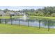 Scenic backyard view of a tranquil pond with fountain and black aluminum fence at 519 Royal Jay Ln., Longs, SC 29568