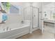 Bright bathroom with soaking tub, glass shower, and view to the bedroom at 519 Royal Jay Ln., Longs, SC 29568