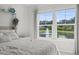 Bright bedroom with view of the lake and fountain through large windows at 519 Royal Jay Ln., Longs, SC 29568