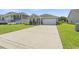 Traditional home exterior with a long driveway, two-car garage, and well-maintained landscaping at 519 Royal Jay Ln., Longs, SC 29568
