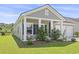 Inviting front porch with rocking chair seating and mature landscaping at 519 Royal Jay Ln., Longs, SC 29568