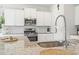 Well-lit kitchen features granite countertops, stainless steel appliances, and modern white cabinetry at 519 Royal Jay Ln., Longs, SC 29568