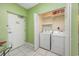 Bright laundry room featuring a side-by-side washer and dryer unit and extra storage shelves above at 5700 N Ocean Blvd. # Ph12, North Myrtle Beach, SC 29582