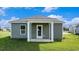 Home exterior features green siding, white trim, a covered patio, and green lawn at 575 Strawberry Field Way, Galivants Ferry, SC 29544