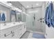 Bright bathroom featuring marble-tiled walk-in shower with glass enclosure, and double sink vanity at 601 46Th Ave. S, North Myrtle Beach, SC 29582
