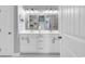 White vanity with double sinks, white cabinets, chrome fixtures, and matching framed mirrors at 601 46Th Ave. S, North Myrtle Beach, SC 29582