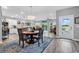 Open dining area with hardwood floors, stylish rug, elegant lighting, and access to outdoor living space at 601 46Th Ave. S, North Myrtle Beach, SC 29582
