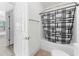 Well-lit bathroom features a tub with patterned shower curtain and neutral-toned flooring at 6010 Windsor Green Way # 301, Myrtle Beach, SC 29579