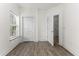 Bright bedroom with wood-look floors, window, closet, and entry door at 6010 Windsor Green Way # 301, Myrtle Beach, SC 29579