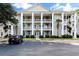 Three-story condo building with white columns, ample parking, and neatly landscaped grounds at 6010 Windsor Green Way # 301, Myrtle Beach, SC 29579