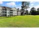 Green lawn behind building with units with balconies at 6010 Windsor Green Way # 301, Myrtle Beach, SC 29579