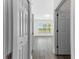 Hallway features wood-look flooring and white doors, leading to a sunlit living space at 6010 Windsor Green Way # 301, Myrtle Beach, SC 29579