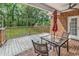 Covered back porch with fan, table, and chairs overlooks lush backyard at 6161 Inman Circle, Conway, SC 29526