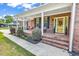 Charming brick home with a welcoming front porch, swing, and well-manicured landscaping at 6161 Inman Circle, Conway, SC 29526