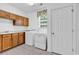 Bright laundry room with modern washer and dryer, ample cabinetry, and a window at 6161 Inman Circle, Conway, SC 29526