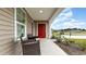 Inviting front porch with seating, complemented by a red door and well-maintained landscaping at 651 Culmen Ct., Myrtle Beach, SC 29588