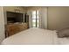 A bedroom featuring a window, a large TV, and a dresser on wood-laminate flooring at 6610 Mallard View Point, Myrtle Beach, SC 29588