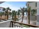 Balcony view showcasing palm trees, parking, pool and a glimpse of the ocean at 7200 N Ocean Blvd. # 260, Myrtle Beach, SC 29572