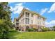 Beautiful exterior view of a home surrounded by lush green grass and mature trees under a blue sky at 730 Pickering Dr. # 303, Murrells Inlet, SC 29576
