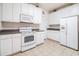 Efficient kitchen features white appliances, ample cabinet space, and tile flooring at 730 Pickering Dr. # 303, Murrells Inlet, SC 29576
