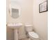 Cozy powder room featuring a pedestal sink, oval mirror, and a decorative beach-themed print on the wall at 730 Pickering Dr. # 303, Murrells Inlet, SC 29576