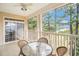 Relaxing screened porch with outdoor furniture and a ceiling fan with views of mature trees at 730 Pickering Dr. # 303, Murrells Inlet, SC 29576