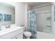 Bright bathroom featuring a tub/shower combo with a leaf-patterned shower curtain and a white sink and toilet at 739 Chazen Way, Longs, SC 29568