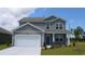 Charming two-story home featuring gray siding, a manicured lawn, and an attached garage at 739 Chazen Way, Longs, SC 29568