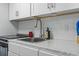 A well-lit kitchen features white cabinets and a stainless steel sink with modern fixtures at 7500 N Ocean Blvd. # 6122, Myrtle Beach, SC 29572