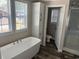 Bright bathroom featuring a soaking tub, window, and storage cabinet, offering a relaxing space at 800 Columbia Dr., Myrtle Beach, SC 29577