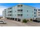Three story condo building with light blue painted exterior walls, white trim, and multiple balconies for each unit at 824 N Waccamaw Dr. # 203, Murrells Inlet, SC 29576