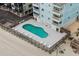Aerial view of a community pool with lounge chairs, nestled near the sandy beach at 824 N Waccamaw Dr. # 203, Murrells Inlet, SC 29576
