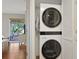 Efficient stacked washer and dryer unit with wood floors and window access beyond at 88 Salt Marsh Circle # 22F, Pawleys Island, SC 29585