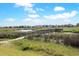 Scenic view of a wooden walkway spanning a tranquil marsh landscape, showcasing a serene coastal community at 88 Salt Marsh Circle # 22F, Pawleys Island, SC 29585