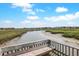 Scenic marsh view of a tidal river with lush grasses and distant waterfront homes, offering serene coastal ambiance at 88 Salt Marsh Circle # 22F, Pawleys Island, SC 29585