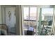Private balcony offers a relaxing retreat with comfortable seating and picturesque views of nearby buildings and palm trees at 9571 Shore Dr. # 318, Myrtle Beach, SC 29572