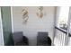 This balcony features wicker chairs, beach themed decorations on wall, and city views at 9571 Shore Dr. # 318, Myrtle Beach, SC 29572