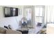 Comfortable living area featuring a TV, relaxed seating, and easy access to a balcony with natural light and views at 9571 Shore Dr. # 318, Myrtle Beach, SC 29572
