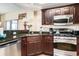 Kitchen boasting stainless steel appliances, dark wood cabinetry, granite countertops, and warm tones at 100 North Beach Blvd. # 710, North Myrtle Beach, SC 29582