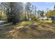 Expansive grassy backyard featuring mature trees and a storage shed on a sunny day at 1044 Martin Ln., Conway, SC 29526