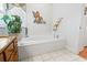 A soaking tub in a bright bathroom with tropical-themed decor and granite countertops at 1044 Martin Ln., Conway, SC 29526