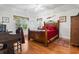 A well-lit bedroom featuring a wooden bed frame, ceiling fan, and hardwood floors at 1044 Martin Ln., Conway, SC 29526